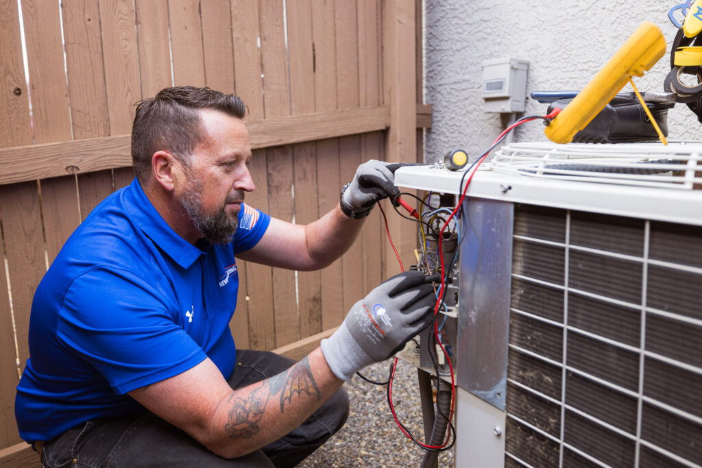 Goettl HVAC technician checking the voltage on an AC unit