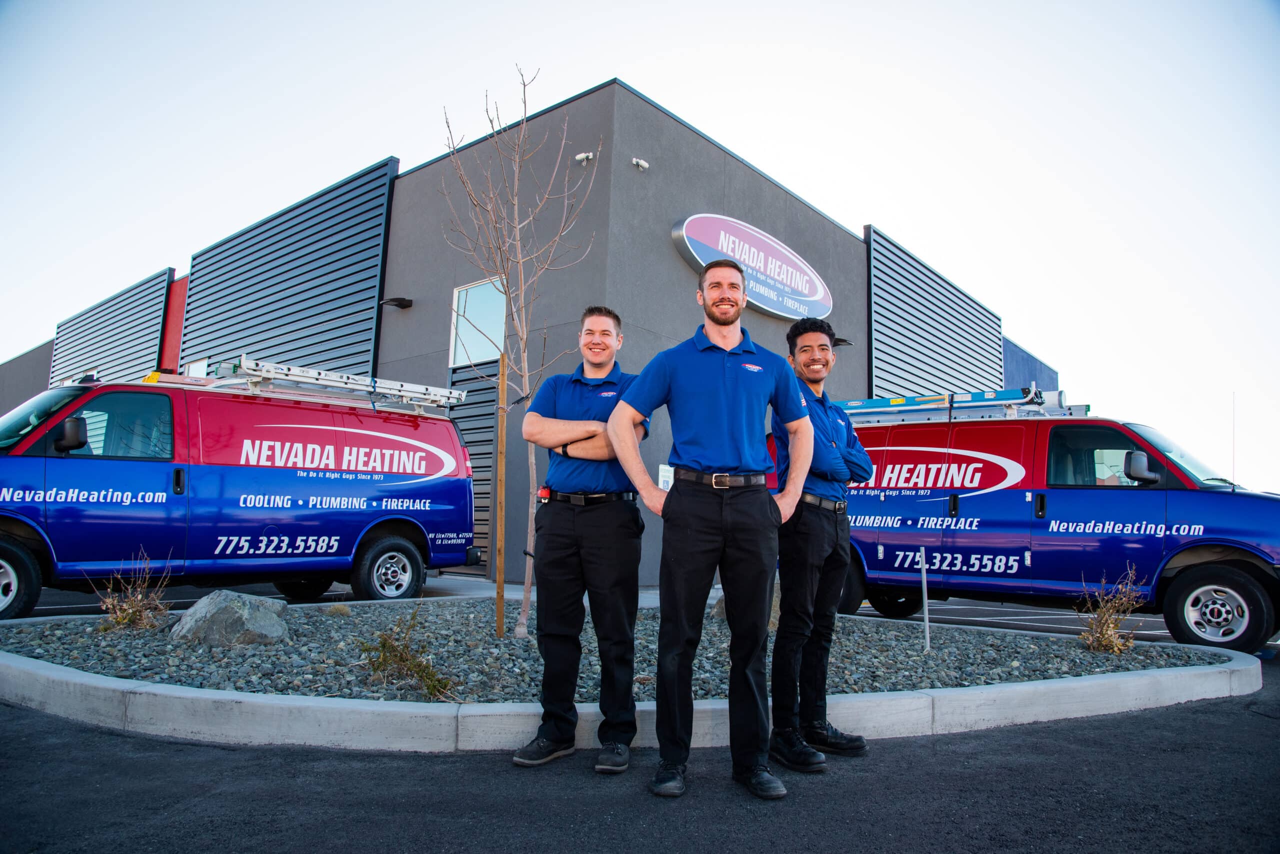 Three employees of Nevada Heating standing outside of their location.