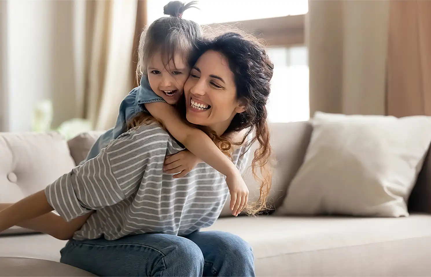 mom-daugher-laughing-on-couch-after-ac-maintenance-service mom-daugher-laughing-on-couch-after-ac-maintenance-service